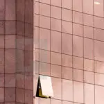 An openable window of glass with the copper cladding tile on left of the façade to match the exterior glass glazing tile grid forms a unique combination of copper and glass