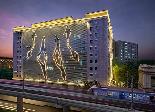 The double-glazed glass and aluminium horizontal fins on the façade run end-to-end in varying widths which resemble human figure silhouettes and solar heat gain