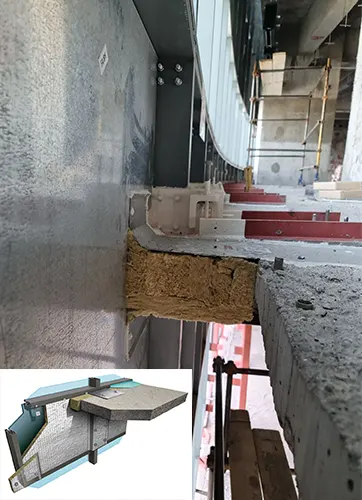 The void between a curtain wall and floor assembly being closed with fire stops