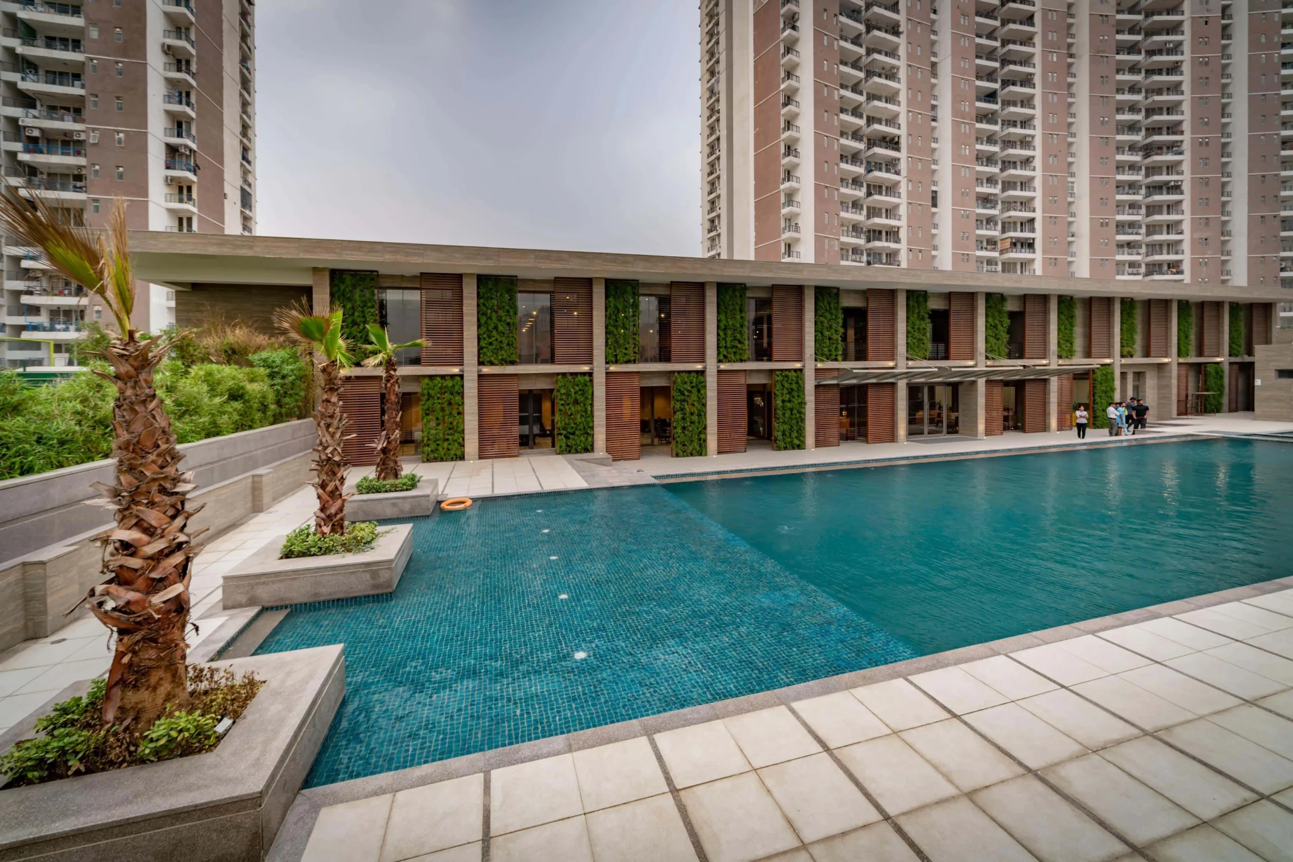 The west façade of the building overlooks the swimming pool, while the other three sides are largely opaque, facing the rear of the society