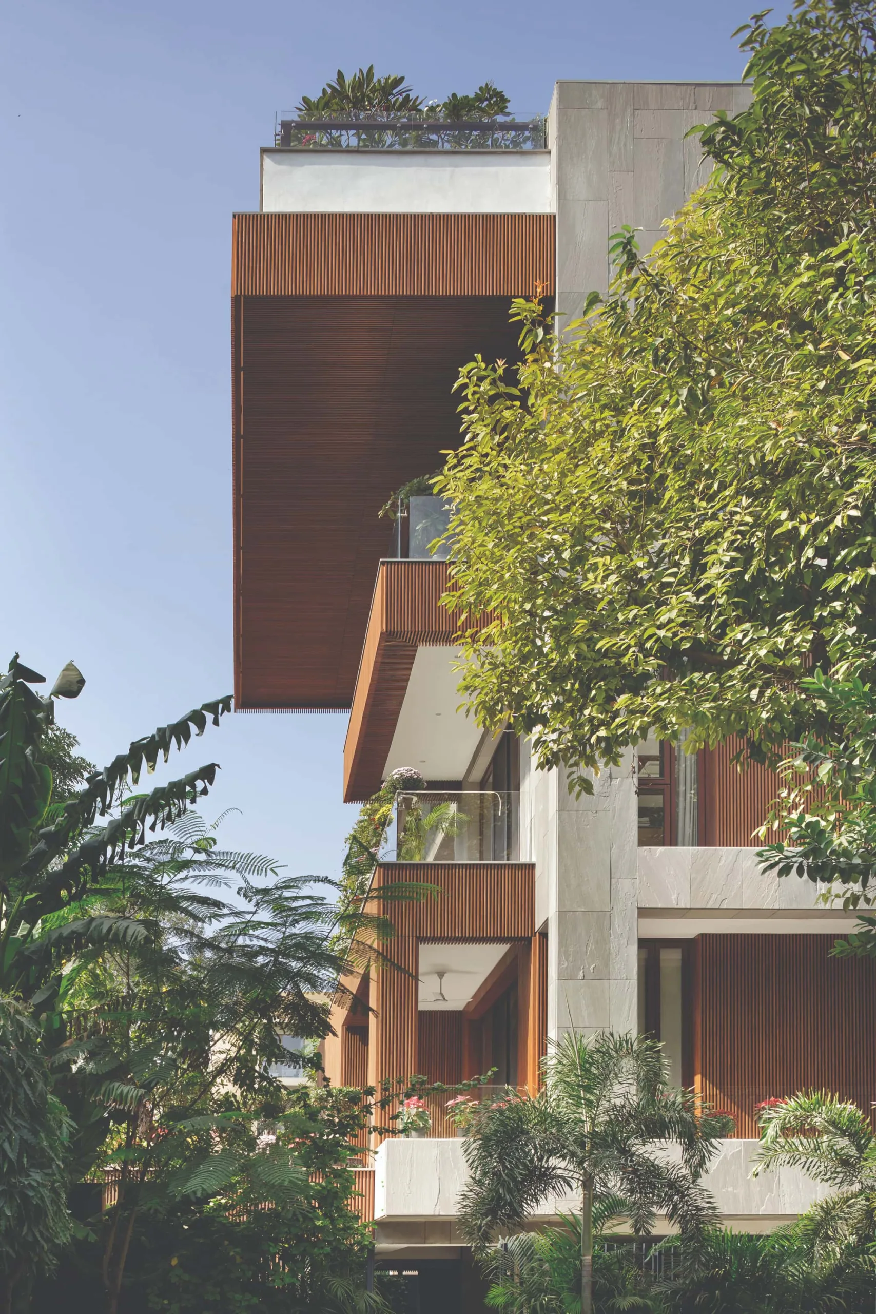 B-10 Residence, New Delhi, A façade defined by sandstone, timber, and expansive balconies to bring light, air, and landscape into every level (Image Credit Noughts And Crosses)