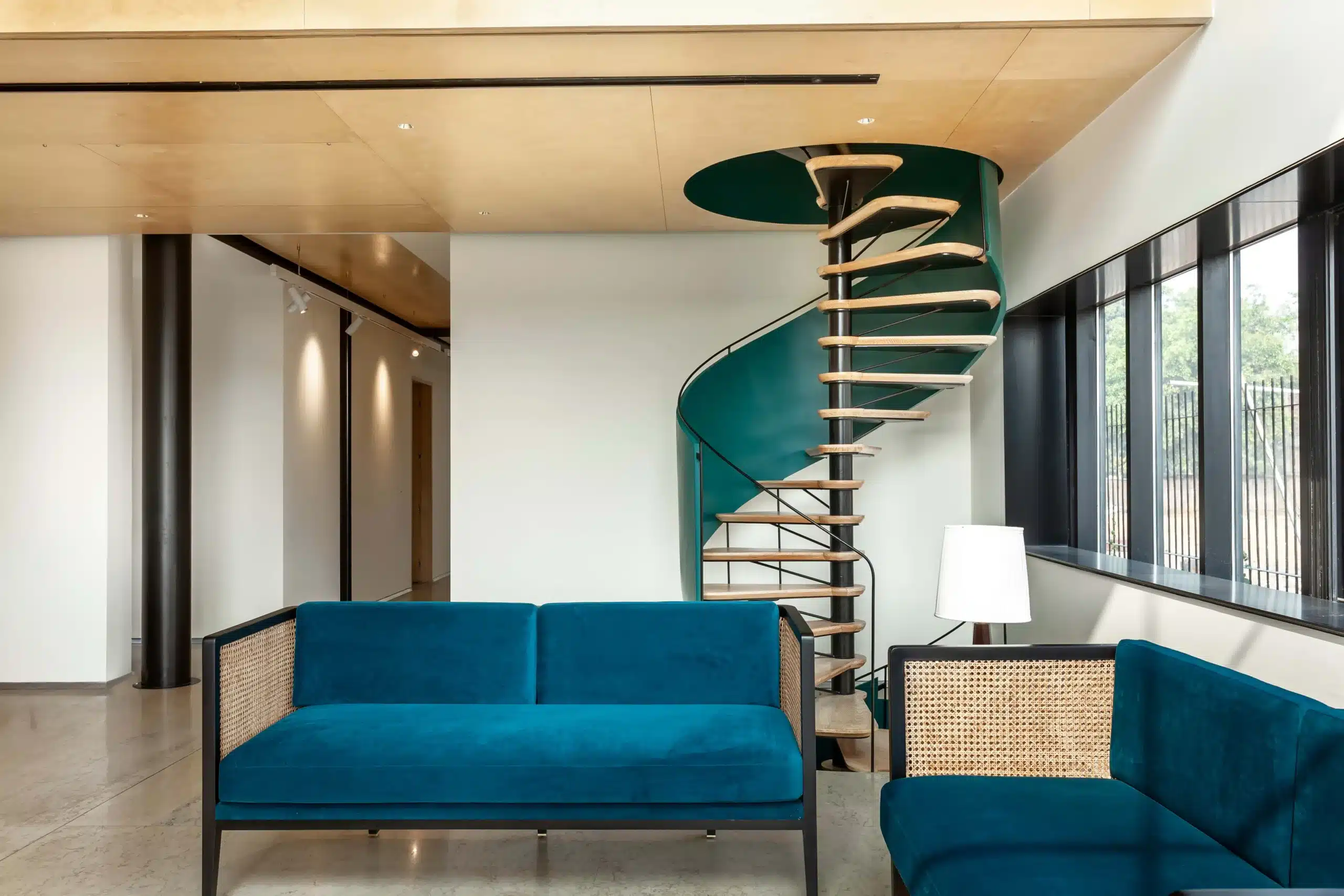 A brightly colored, animated spiral staircase with metal wrapping connects the formal living room to the formal dining area