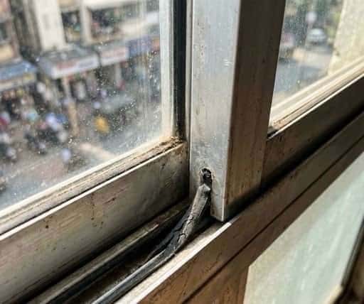 A typical sliding window meeting rail joint showing worn weatherstripping. The seal gap at this junction is a continuous line of sound leakage across the full width of the window