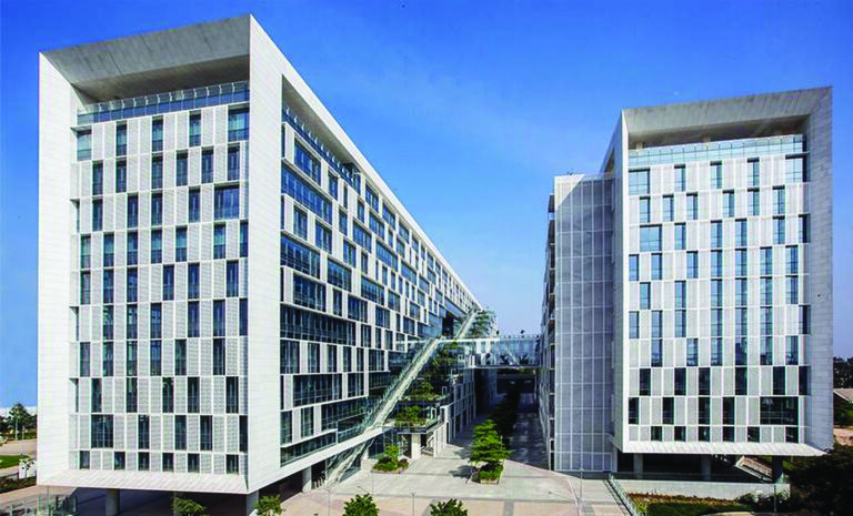 Narrow west-facing elevations carry the heaviest density of perforated screening and solar films, layered over high-performance double glazing — the orientation given the most defense on an otherwise open building.