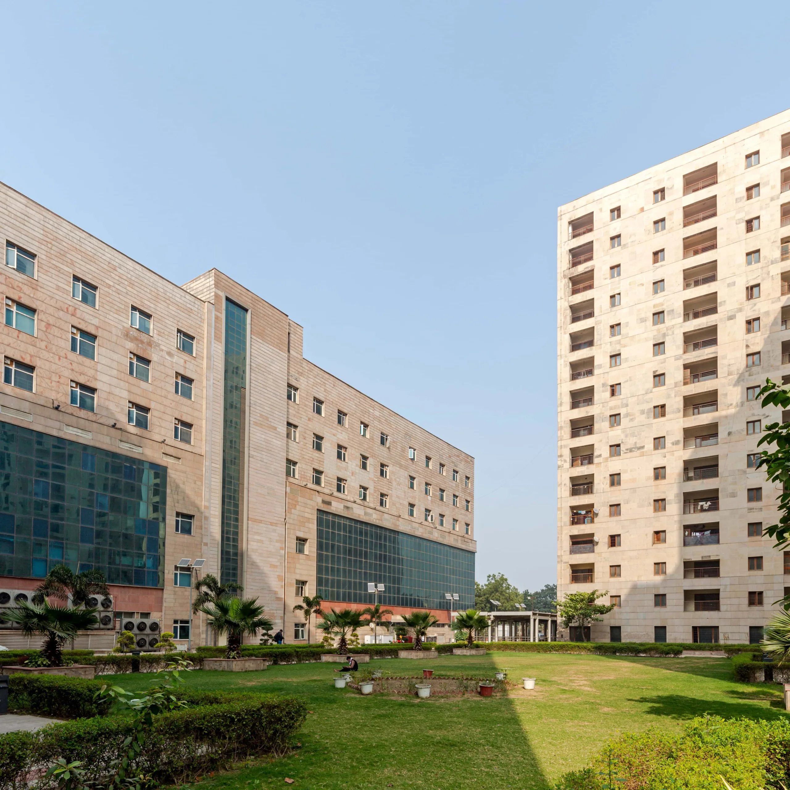 Academic and clinical blocks articulated through high thermal-mass stone façades and recessed fenestration, optimising daylight control, thermal stability, and long-term durability across a medical education campus. Project: Super Speciality Post Graduate Hospital and Child Health Institute, Noida