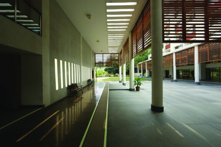 The clubhouse deep recessed courtyards and covered walkways create shade for gatherings without mechanical cooling