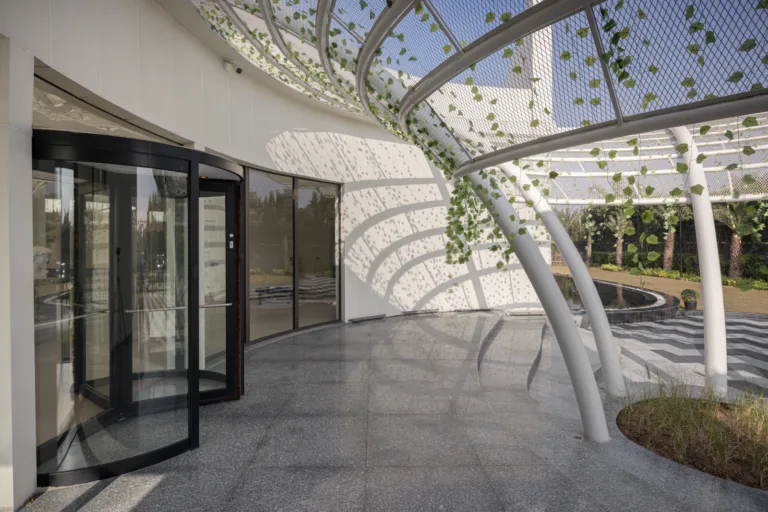 A modern jaali-inspired shading structure filters harsh sunlight and creates a buffer against dust-laden winds.