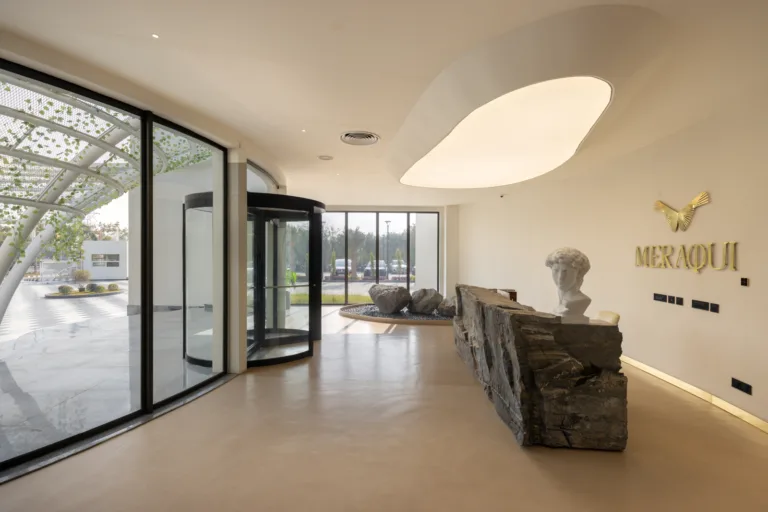 Perforated jaali screens and natural stone detailing bring climate-responsive design indoors.