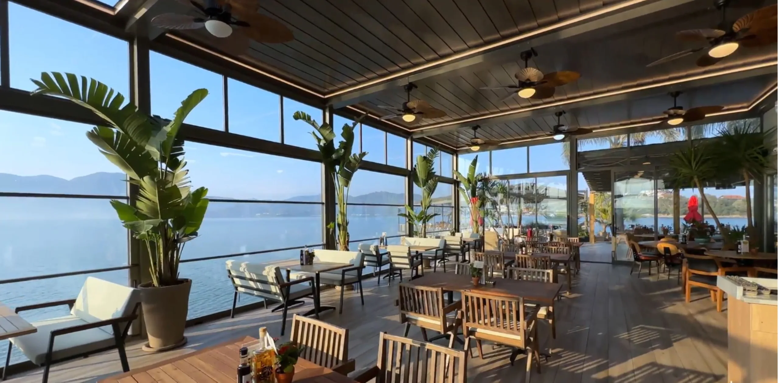 All-Weather Hospitality Terrace - A waterfront hospitality terrace enclosed with full-height vertically sliding glazing, extending the operational use of outdoor dining areas while maintaining transparency and an uninterrupted view.