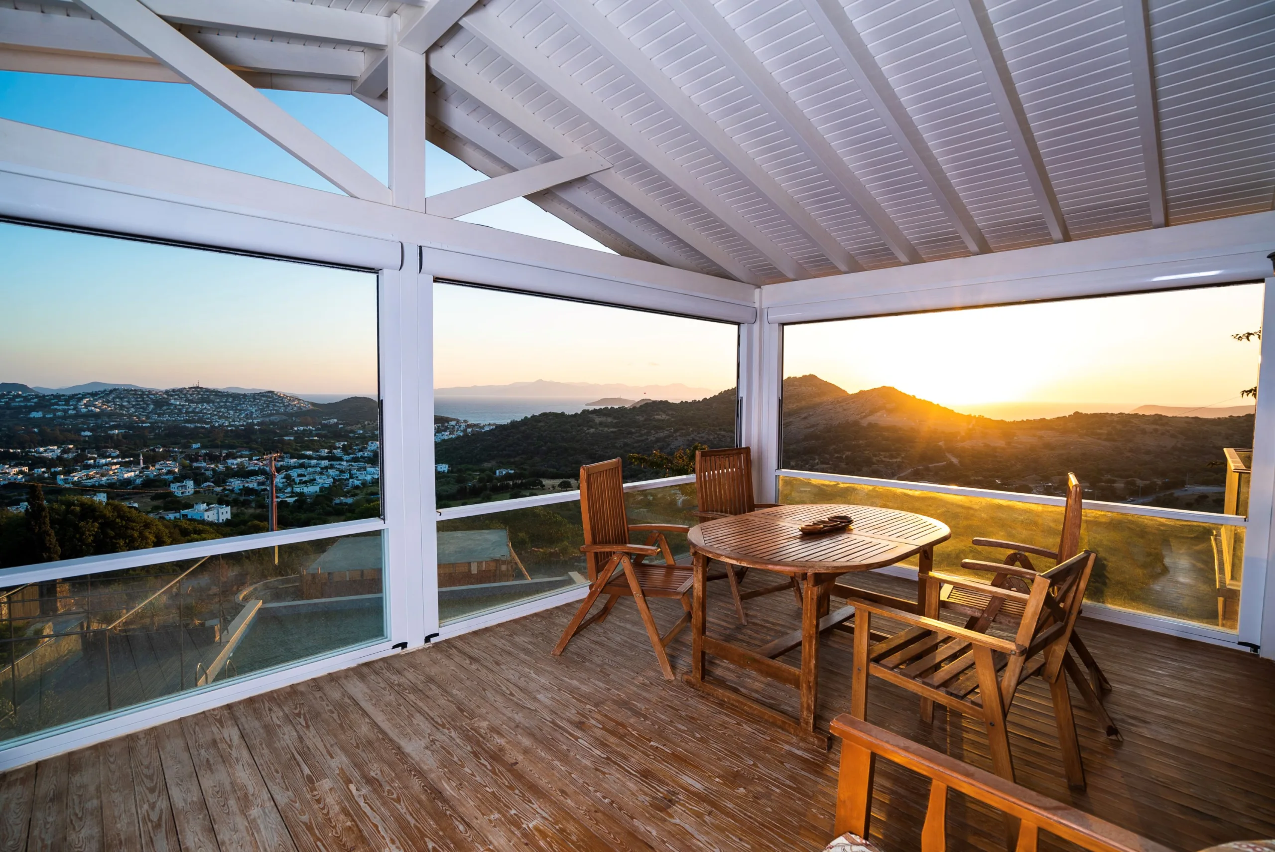 Panoramic Outdoor Living Space - A glazed residential outdoor space overlooking a natural landscape, demonstrating how vertical sliding glazing preserves panoramic views while providing protection from wind, rain and external noise.