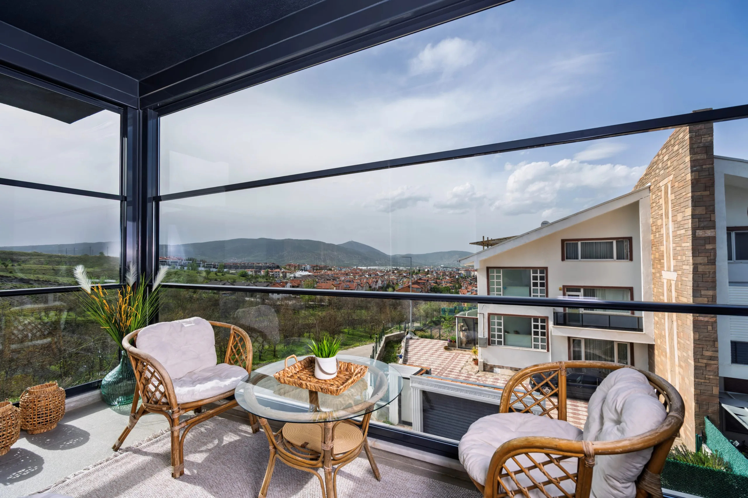 Residential Balcony with Vertically Sliding Glazing - A residential balcony featuring vertically sliding glazing in the open configuration, allowing uninterrupted views and natural ventilation while enabling rapid enclosure during changing weather conditions.